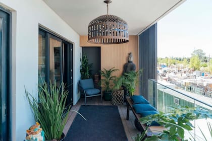 La presencia de azul en este balcón con propuesta de sillón, almohadones y alfombra