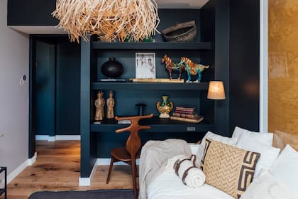 Los pisos de Patagonia Flooring en excelente combinación con el tono profundo de Colorín, los zócalos blancos y los dorados y crudos de la decoración Silla valet (Harturo).