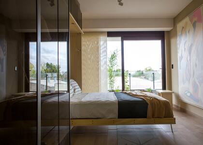 En el dormitorio, piso 'Tiaga Almendra' (San Lorenzo Design). En el balcón se planteó una suerte de mini jardín zen (@roca.urban.nature).