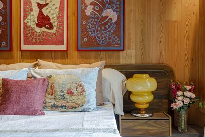 Arriba del respaldo de cama, obras de Abril Tanoira (Diderot.art). Lámpara ´Bubble Honey´ (Dammax Antik Hunters). Flores (Las Casianas).