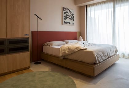 Cama 'Snooze' con cajones y respaldo tapizado (Marini Estudio). Colchón (Rosen). Ropa de cama (The Linen Store). El placard realizado por Dwell con melamina 'Paraíso' (Faplac) tiene una franja de cajones de vidrio fumé con perfiles color champagne (Rehau).