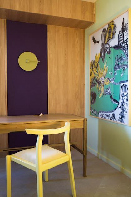 Escritorio 'Samurai' y silla 'Asta', esta vez en amarillo (Marini Estudio). El espacio se integra visualmente con el resto de la casa por medio de los materiales, como el porcelanato de acabado pétreo en gris cálido (San Lorenzo Design).