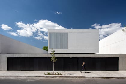 En la fachada se usó hormigón visto y un cerramiento de aluminio negro que esconde la puerta de acceso y los portones para los autos.