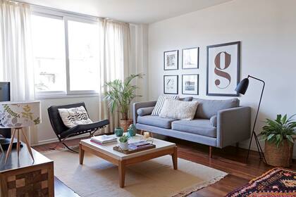 Sofá gris con almohadones (Tienda South), lámpara de pie (Ikon Lamps), cómoda de TV y mesa ratona de petiribí y lino laqueado (ambas de Las Marinas Muebles).