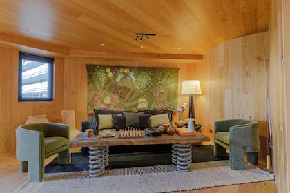 Sillones, sofá y almohadones (Estudio 11.11). Vasijas (Casa Clara). A la derecha, Caña de Pescar por Mercolina Dipierro (Diderot.art). La iluminación de acento propuesta por el equipo de Cappiello+Partners, Lighting Design, se ejecuta con luminarias orientables de IDEA. (Arq. Emi Cappiello y Arq. Diana Portillo).