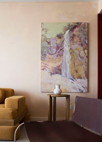 El sillón 'Forastero' (Marini Estudio) replantea materiales tradicionales del campo argentino, como el hierro y el cuero vacuno. Óleo 'Susurro Fulguroso' de Catalina White (Diderot.art).