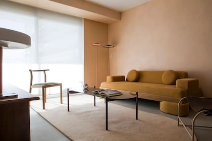 Sillón 'Atlas', mesa baja 'Pantera' con tapa de vidrio y silla 'Asta' al natural (Marini Estudio) Alfombra (El Espartano). Sobre el tono 'P021-2' de Colorín, trabajaron con dos más para darle un aspecto estucado. A las lámparas de pie 'Zen' (Fábrica de Luz) las pintaron en tonos mandarina y chocolate.