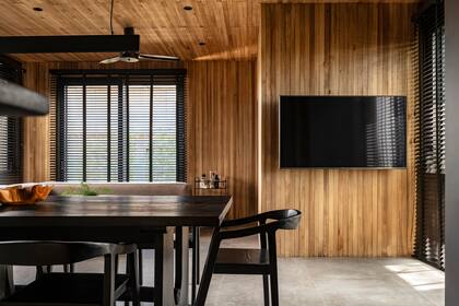 Prescindiendo de elementos que entorpezcan la circulación, la tele se colocó sobre una de las paredes revestidas en madera.