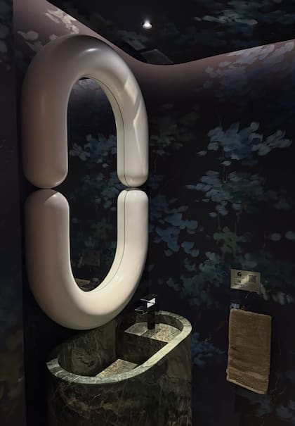 Espejo (Estudio Leti Rocco). Bacha con pie de mármol pulido 'Verde Arcadia' (De Stefano). Grifería 'Dominic' (FV). Las formas se potencian con un sobretecho iluminado (Durlock) que suma profundidad.