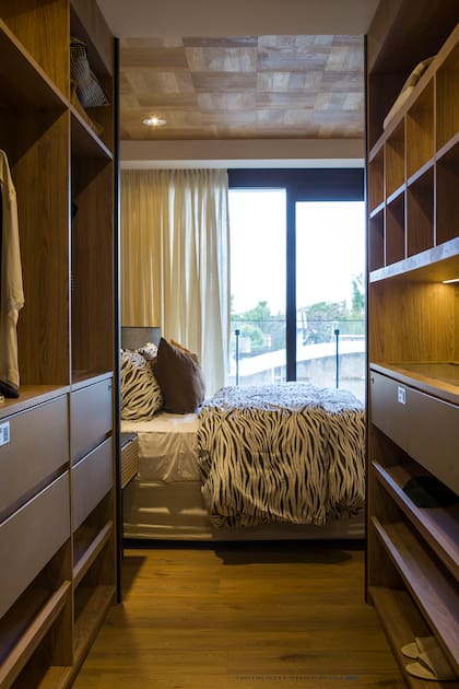 Amamos los vestidores. Este conecta el dormitorio con el baño en suite. Se realizó en placas Faplac Olmo y Gris Tapir.