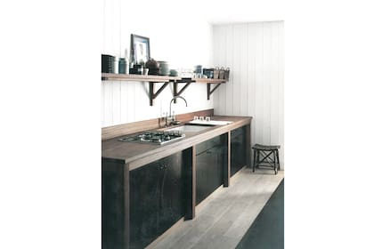 Foto: En esta cocina, el lustre oscuro, casi negro, del mobiliario contrasta con el machimbre blanco de las paredes (foto: themarchcollective.com).