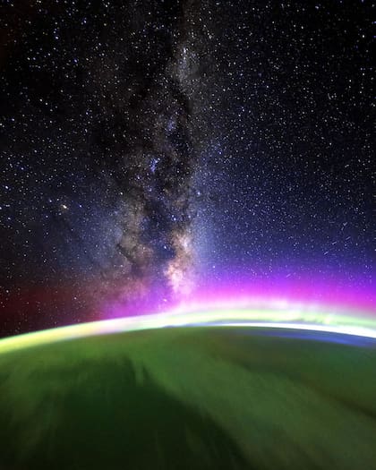 Foto tomada desde el espacio el 27 de enero, mientras el Sol comenzaba a salir sobre un océano Pacífico nublado; muestra la amplia franja de la Vía Láctea, nuestra galaxia, sobre la aurora (Foto: NASA)