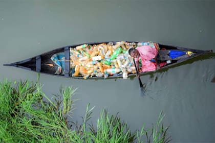 Foto viralizada de un hombre que recoge plásticos en el río Meenachil, en India