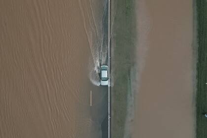 Fotografía aérea que muestra un vehículo que transita por una carretera inundada este miércoles en San Nicolás de los Arroyos, en la provincia de Buenos Aires