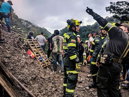 Fotografía cedida por la oficina de prensa de la Policía Nacional de Colombia que muestra a rescatistas trabajando en el sitio de un deslizamiento de tierra en el sector El Ruso, municipio de Pueblo Rico, en el noroeste de Bogotá, Colombia, el 4 de diciembre de 2022.