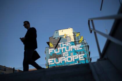 Fotografía de archivo del 23 de julio de 2019 de un hombre caminando frente a una pintura de arte callejero que lee "El futuro es Europa", en Bruselas. (AP Foto/Francisco Seco)