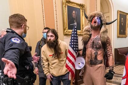 Fotografía de archivo del 6 de enero de 2021 donde aparece Jacob Chansley (derecha) participando en el asalto al Capitolio estadounidense en Washington. (AP Foto/Manuel Balce Ceneta, Archivo)