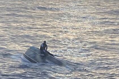 Fotografía divulgada por la sección Sureste de la Guardia Costera estadounidense donde se aprecia a un sobreviviente de un naufragio aferrado en un bote frente de la costa de Fort Pierce, a unos 240 kilómetros al norte de Miami.