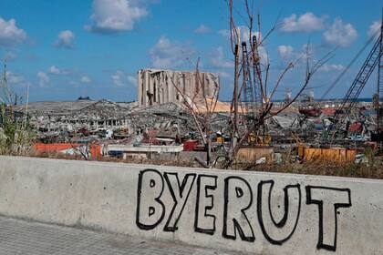 Fotografía tomada el 9 de agosto de 2020 muestra un graffiti en la pared de un puente que domina el puerto de Beirut, el lugar de la explosión que mató al menos a 154 personas y devastó zonas de la capital.