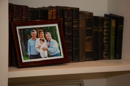 Fotografías de Franco Macri con su hijo Mauricio y Juliana Awada se mantienen en la biblioteca de la casa que hoy está a la venta.