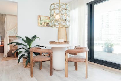 En el departamento "La Orilla", presentado con Iván Nahas, mesa redonda con pie torneado y laqueado en blanco roto con una gota de gris, sillas tapizadas en cuero y espectacular lámpara colgante (todo de Wood Market).