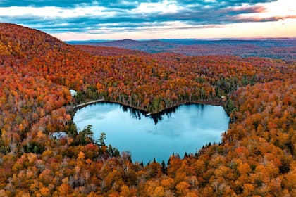 El lago Baker, con forma de corazón, está rodeado de colores otoñales el 8 de octubre de 2022 cerca de East Bolton, Quebec, Canadá