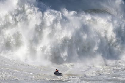 Una moto de agua se aleja de una ola rompiendo durante una competencia de surf de olas grandes en Praia do Norte, en Nazare, Portugal, el 25 de febrero de 2022