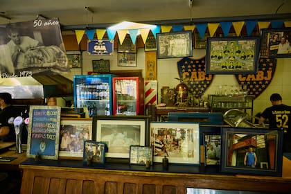 Fotos y recuerdos sobre la barra; muchos fueron aportados por clientes e hinchas