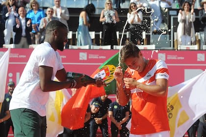 Frances Tiafoe "bañando" a Sebastián Báez, el campeón del Estoril Open, durante la premiación. 