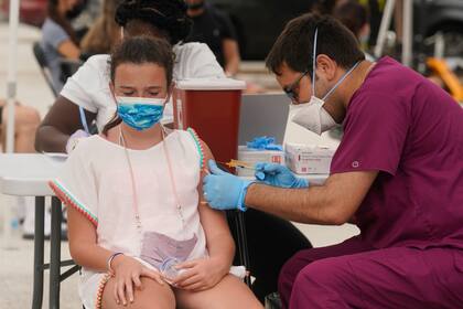 Francesca Anacleto, de 12 años, recibe su primera dosis de la vacuna de Pfizer contra el COVID-19 aplicada por el enfermero Jorge Tase en Miami Beach, Florida