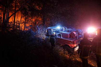 Un bombero permanece junto a su vehículo en un incendio forestal cerca de Belin-Beliet, en el suroeste de Francia, el 11 de agosto de 2022.