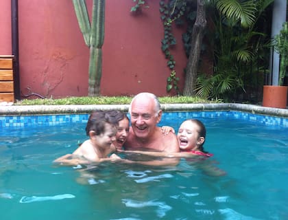 Francisca, Josefina e Iván en la pileta, con el abuelo Hugo