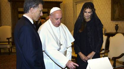 Francisco les muestra a Macri y a Awada uno de los documentos que les regaló