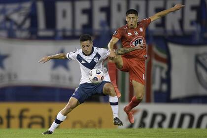 Francisco Ortega lucha por el balón con Simón Ramírez; Vélez sacó boleto a octavos