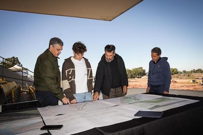 Entre el jefe de gobierno de la Ciudad de Buenos Aires, Jorge Macri, y el secretario de Deportes, Fabián Turnes, Colapinto mira el plano de las obras de renovación del autódromo Oscar y Juan Gálvez.