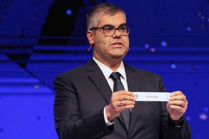 Frederico Nantes, director de competiciones y operaciones de la CONMEBOL, muestra el papel con el nombre de Racing Club