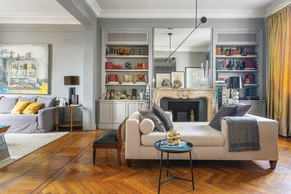 Frente a chimenea estilo Luis X V comprada en remate, chaise longue (Arq. Negro Williams) con almohadones (Compañía Argentina) y manta (Elementos Argentinos). Lámpara de techo(Fábrica de Luz) y mesita de chapa (Hábito) con calavera dorada (Marcelo Mazza)..