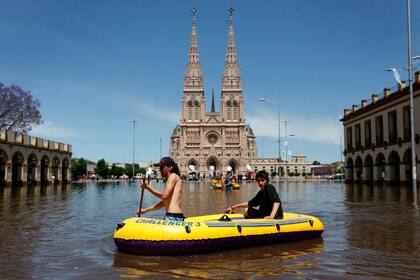 Frente a la basílica, navegan en un bote inflable; ayer ése fue el medio de transporte preferido en Luján