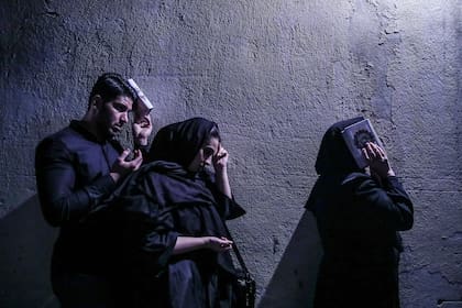 Frente a un santuario de Teherán, Irán, un grupo de musulmanes reza durante el Ramadán de mayo de 2019