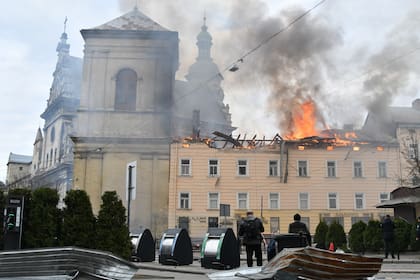 Fuego y humo se elevan sobre el centro de la ciudad tras un ataque de dron en Leópolis, Ucrania, el martes 24 de marzo de 2026. (AP Foto/Mykola Tys)
