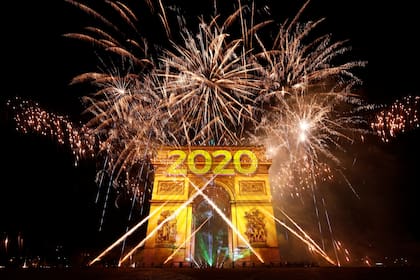 Fuegos artificiales y proyecciones iluminan el Arco de Triunfo en París, Francia