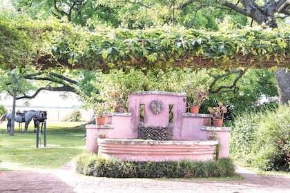 Fuente de inspiración italiana. En su base, un borde de pasto inglés.