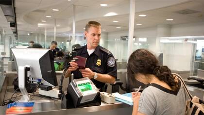 Funcionario de la CBP controla a pasajera que intenta ingresar al país
