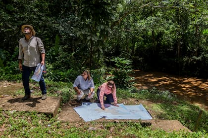 Funcionarios del canal examinan mapas de la propuesta para la presa de río Indio