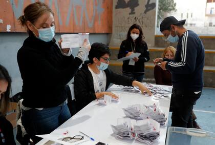 Funcionarios electorales cuentan las papeletas tras el cierre de las urnas durante el referéndum para aprobar o rechazar una nueva Constitución, en el colegio electoral de Santiago, el 4 de septiembre de 2022. 