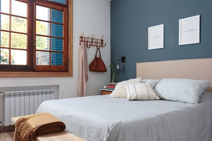 Funda del respaldo y acolchado (Deco con Alma). Banco al pie de la cama y almohadones (Rancho Deco). Manta de lana (Elementos Argentinos). Mesa de luz y perchero (Hydra Home). Apliques (Hado de Luz Lámparas).