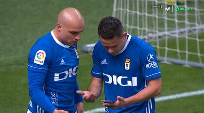Futbolistas de Oviedo miran la tabla de posiciones en el celular tratando de buscar explicaciones