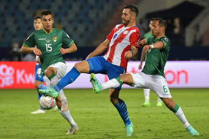 Gabriel Avalos lucha por el balón con Boris Céspedes y Leonel Justiniano; el delantero de Argentinos dio la asistencia para el tercer tanto guaraní
