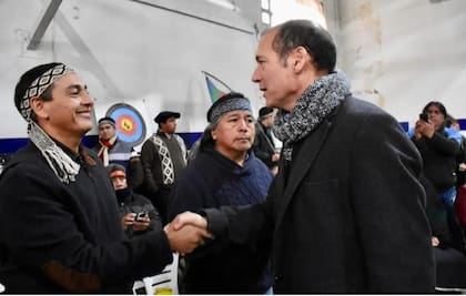 Gabriel Cherqui y Jorge Nahuel, de la Confederación Mapuche, saludan al gobernador neuquino, Omar Gutiérrez