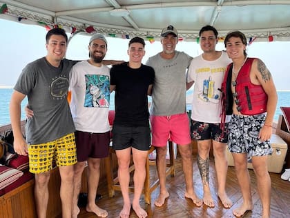 Gabriel, de traje de baño rosa, junto a sus hijos y Julián Álvarez